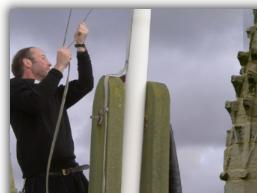 Rev Ian Wallis hoists the Feast flag - Click to Enlarge